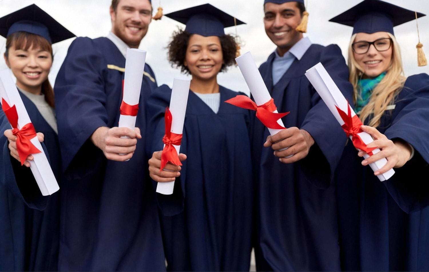 Group of CBSE graduates in caps and gowns holding diplomas after finishing school in the UAE
